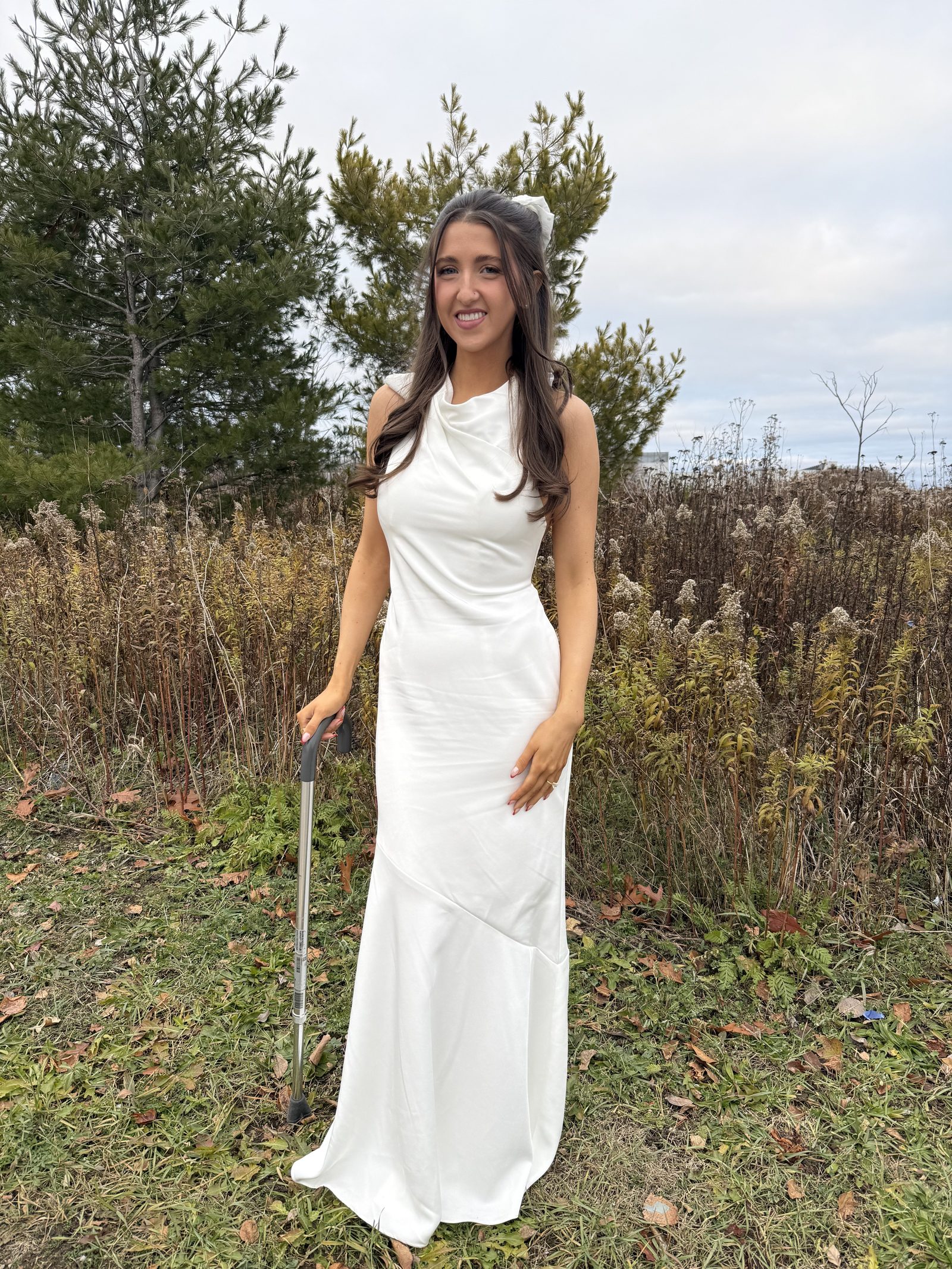 Kale Vine in a white wedding dress standing in an open field, looking radiant