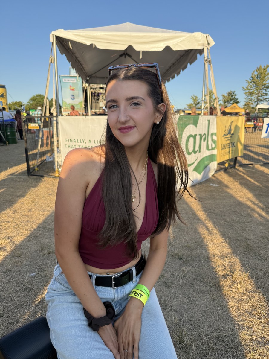 Kale Vine at an outdoor festival in a burgundy halter top in golden hour light